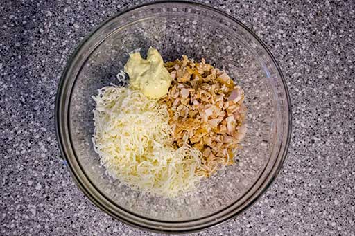 Add finely chopped chicken, grated cheese and mayonnaise into a bowl and then mix well