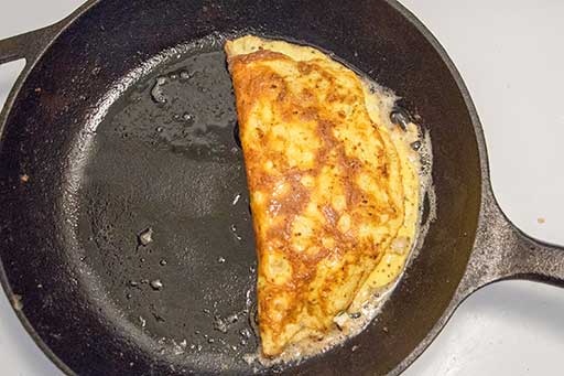 Gently fold the omelette using a spatula .