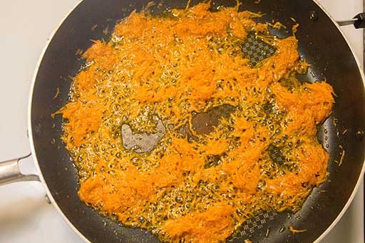 Add grate carrots onto the skillet with lard. Fry until golden brown.