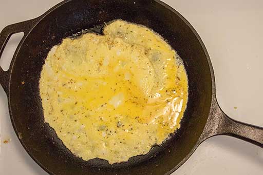 Spread the egg mixture over preheated skillet using ladle and then cover the pan with a lid for a few minutes